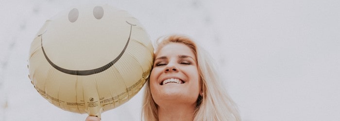 Femme tenant un ballon avec un visage souriant